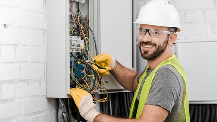 Ein Elektriker arbeitet an einem Stromverteilerkasten