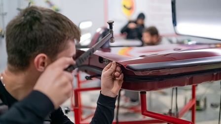 Dellentechniker beim ausbeulen einer PKW Tür