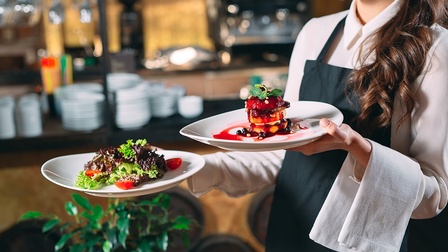 Eine Kellnerin serviert Essen in einem Restaurant.