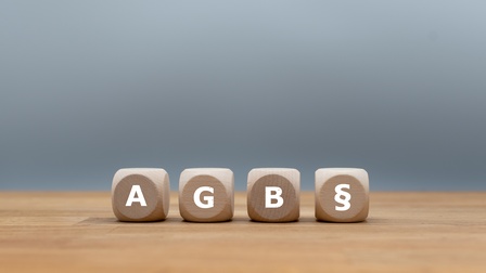 Vier Würfel mit Abkürzung AGB und Paragraph Symbol