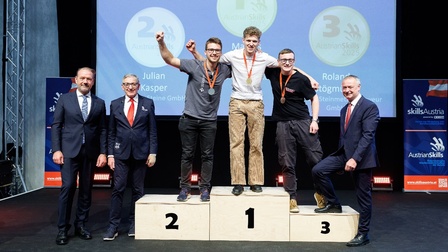 Die ersten drei Gewinner jubeln auf der Siegertreppe