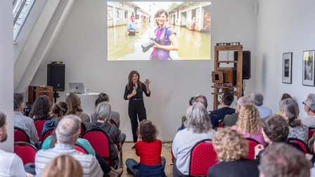 stehende Frau mit Mikro hält Vortrag