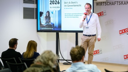 Stehender Mann mit Mikro auf einer Bühne