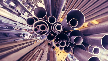 Detailansicht rechteckiger Metallstäbe sowie Metallröhren, deren Öffnungen in die Kamera zeigen. Dünnere Röhren sind sind in dickere Röhren gesteckt, die wiederum übereinander geschichtet sind 