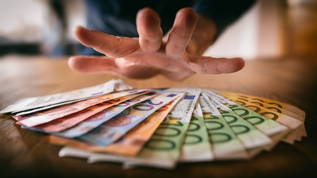 Hand über Geldscheinen