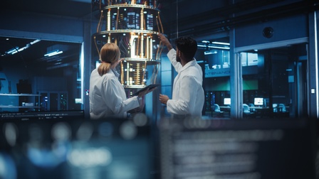 In weißen Kitteln gekleidete Ingenieure arbeiten gemeinsam an der Entwicklung eines Quantencomputers.