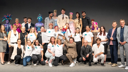 Gruppenfoto der Teilnehmenden des Bundeslehrlingswettbewerbs Styling & Frisuren auf einer Bühne.