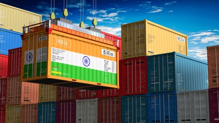 Im Vordergrund ist ein großer Container, auf dem die indische Flagge ist. Dahinter sind viele weitere, gestapelte Container