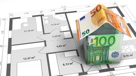Euroscheine sind zu einem Haus geformt und stehen auf einem Grundriss eines Hauses