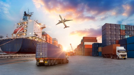 Vektor-Illustration eines asphaltierten Bodens, auf dem mehrere LKWs sind. Hinter den LKWs sind gestapelte Container. Links neben ihnen ist ein großes Schiff. Über ihnen fliegt ein Flugzeug