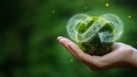 Hand hält eine grüne Mooskugel in der Hand, die eine zirkulierende Ökonomie symbolisiert und als Konzept für künftiges Wirtschaftswachstum und nachhaltige Umwelt dient, Konzept zur Reduzierung von Müll für zukünftiges Wirtschafts- und nachhaltiges Umweltwachstum