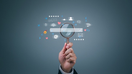 Vektor-Illustration eines dunklen Hintergrunds, in dessen Mitte das Eingabefeld einer Suchmaschine ist. Um das Feld liegen verschiedene Symbole, wie Sprechblasen, Pfeile, ein Kuvert, eine Silhouette. Eine Person hält eine Lupe darauf