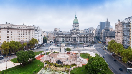 Stadtansicht von Buenos Aires, großer zentraler Platz mit Statue umgeben von Grünflächen und Bäumen, historischen Gebäude im Zentrum mit Rundkuppel