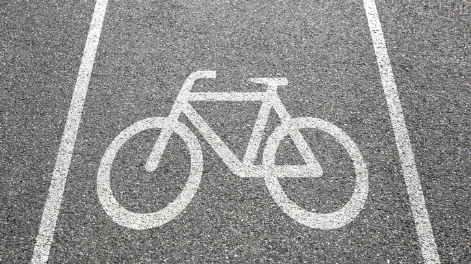 Detailansicht Asphaltstraße mit weißem aufgemalten Fahrradzeichen