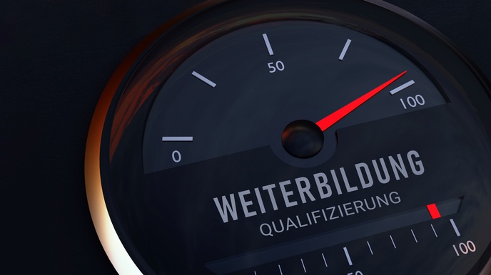 Nahaufnahme eines runden Objektes mit einem Bildschirm. Auf dem Bildschirm ist eine rote Nadel sowie die Zahlen null bis hundert in einem Halbkreis. Darunter steht Weiterbildung und Qualifizierung.