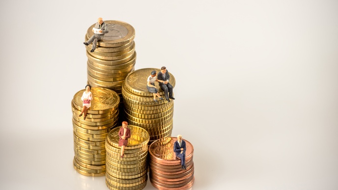 Fünf Türmchen aus aufeinandergestapelten Euro-Münzen, auf denen kleine Figuren von Personen sitzen