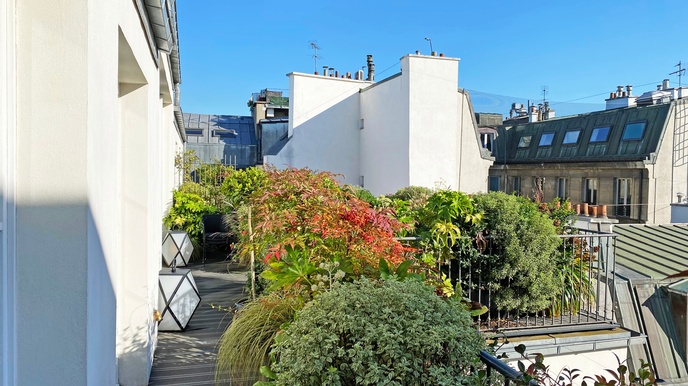 Begrünter Balkon einer Wohnung im letzten Stock eines Hauses