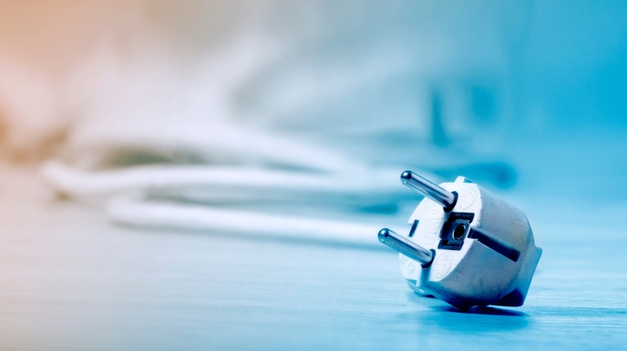 Detailansicht eines Stromsteckers mit Kabel in blauem Licht