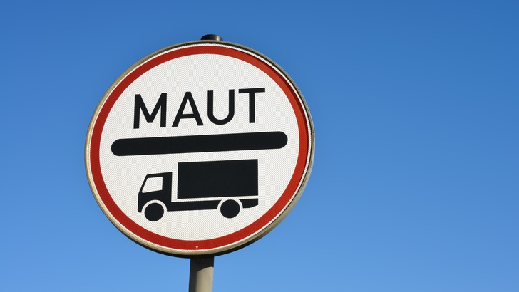 Maut-Schild für LKW mit schwarzem Symbol vor blauem Himmel