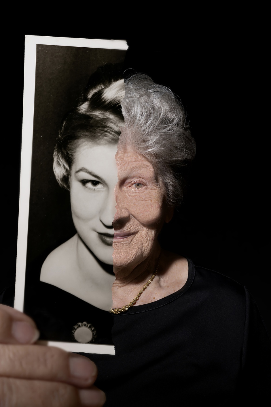 Person hält ein Porträtfoto vor das eigene Gesicht.