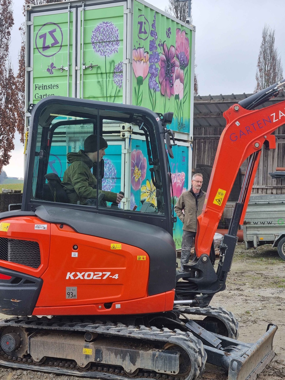 Ein Jugendlicher lenkt einen Minibagger.