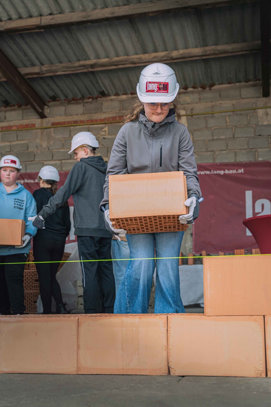 Mädchen setzt Mauerziegel.