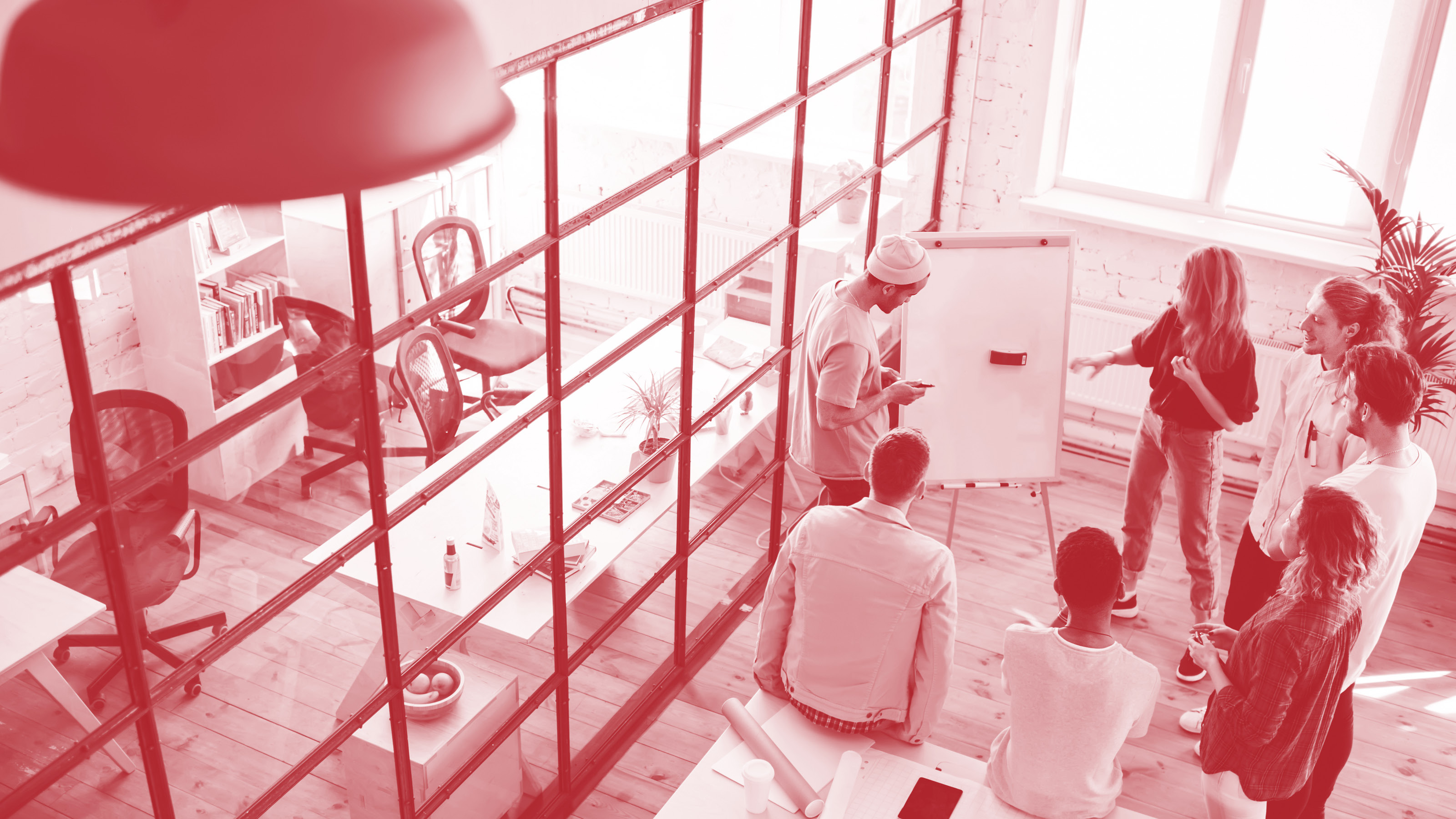 Junges Team beim Brainstorming vor einem Whiteboard in einem offenen B&uuml;ro