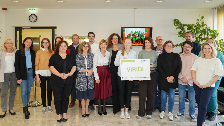 Gruppenfoto mit 18 Personen, in der Mitte halten zwei Frauen ein Plakat vom Projekt VIRIDI