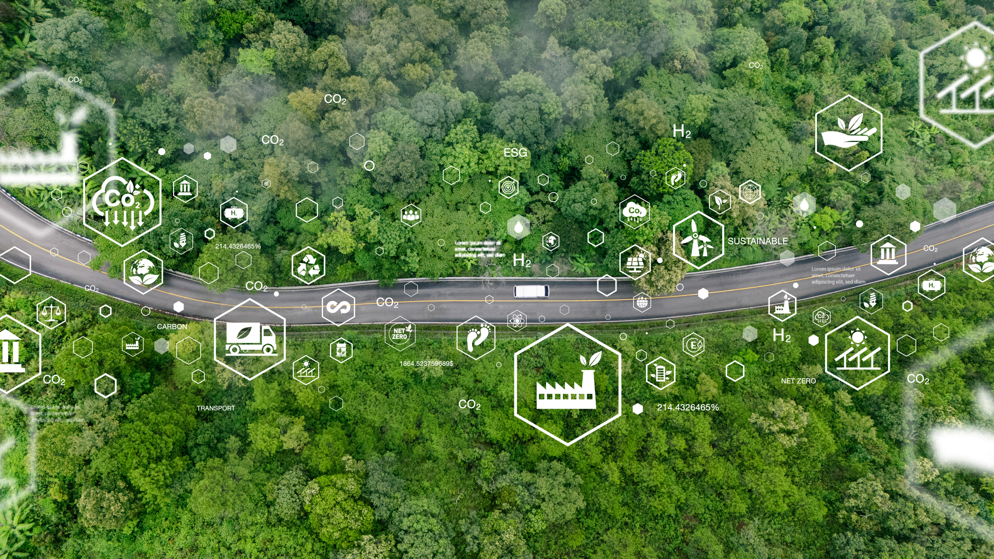 Aufnahme einer zweispurigen, asphaltierten Stra&szlig;e, die durch einen Wald mit gr&uuml;nen B&auml;umen horizontal f&uuml;hrt. Dar&uuml;ber sind verschiedene Symbole angeordnet wie Solarzellen, eine Weltkugel mit Bl&auml;ttern und weitere