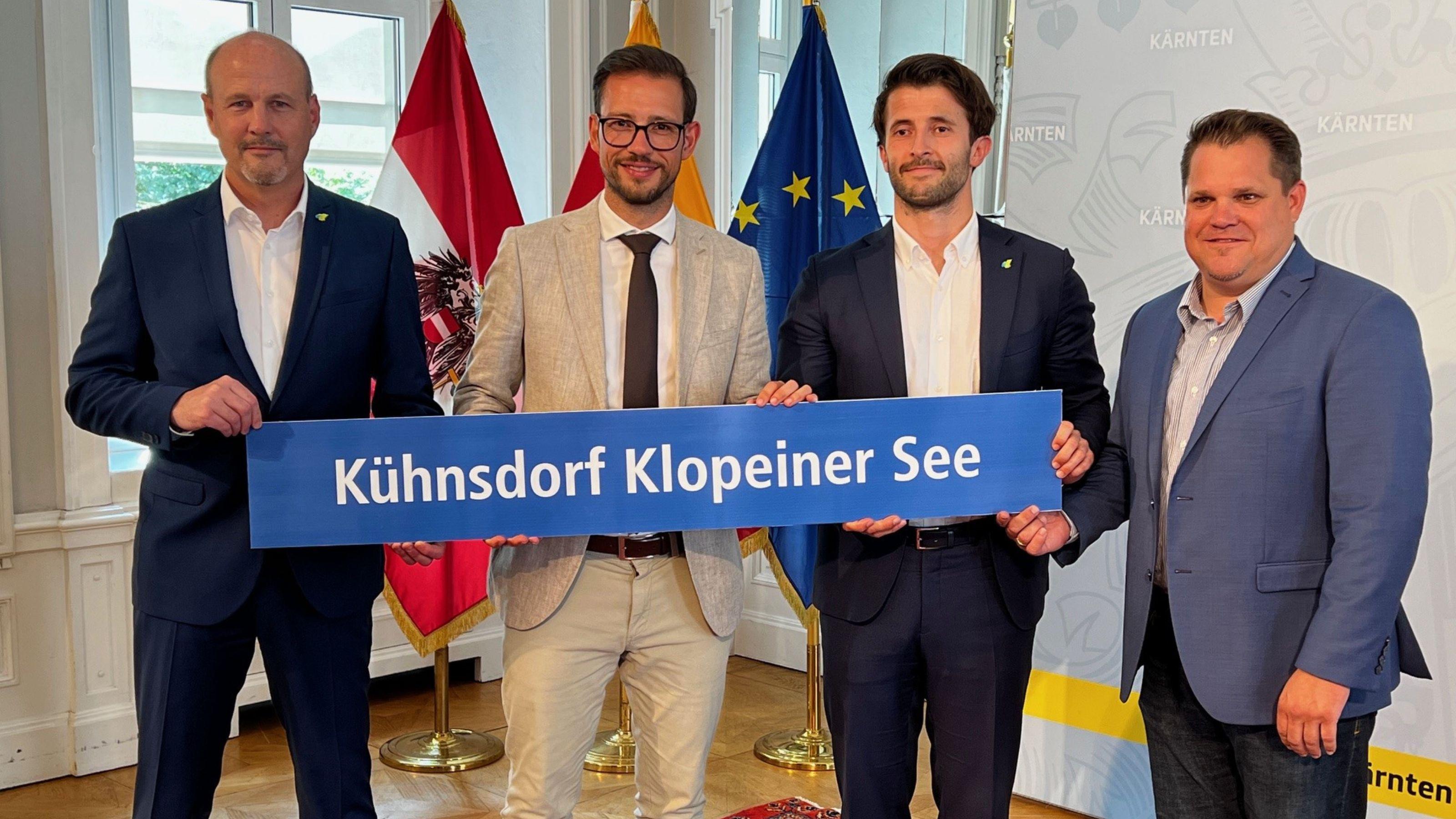 Gruppenfoto von Land und Westbahn im Spiegelsaal mit Fahnen im Hintergrund