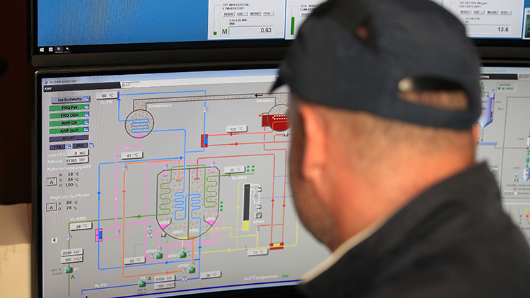 Person vor Bildschirm einer umwelttechnischen Anlage