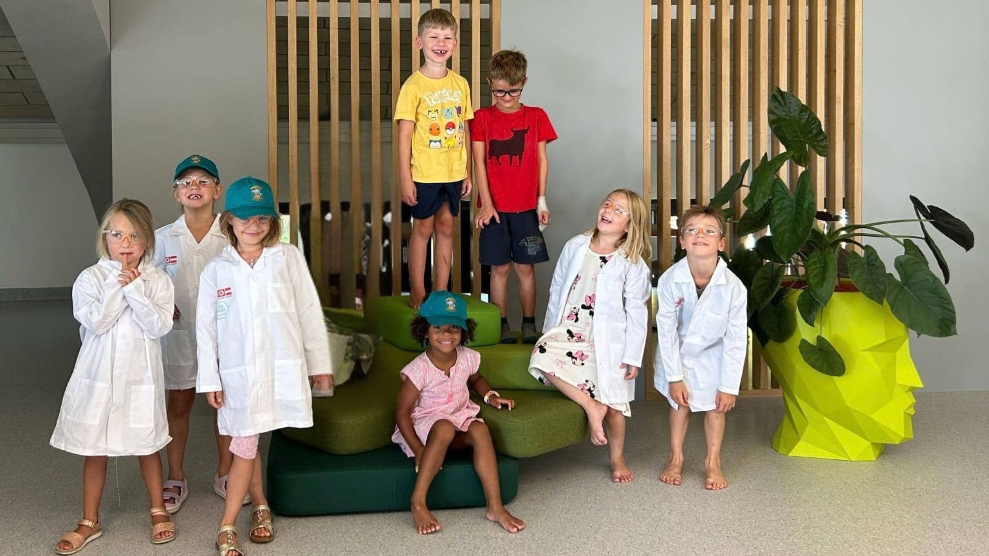 Eine Gruppe von Kindern in Forscherm&auml;nteln.