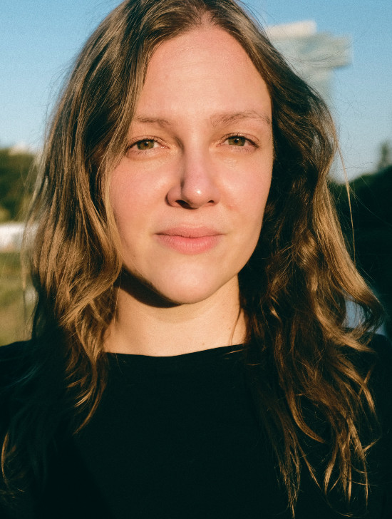 Portr&auml;tfoto: Person mit langen hellbraunen Haaren im Freien bei Sonnenlicht