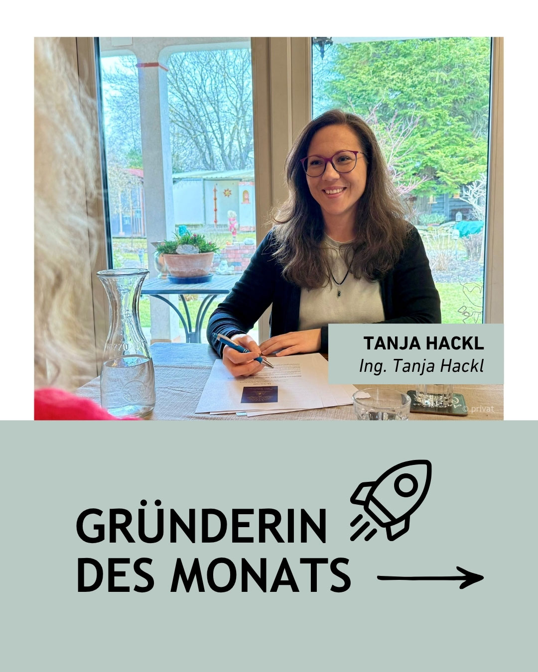 Eine Frau sitzt an einem Tisch und f&uuml;hrt ein Gespr&auml;ch. Vor ihr liegen Papierunterlagen und ein Stift. Im Hintergrund ist ein gro&szlig;er Fensterbereich mit Blick in einen Garten zu sehen. Rechts im Bild steht ein Textfeld mit dem Namen &bdquo;Tanja Hackl&ldquo;. Unter dem Foto befindet sich ein grafisches Element mit der Aufschrift &bdquo;Gr&uuml;nderin des Monats&ldquo; und einem Raketen‑Symbol.