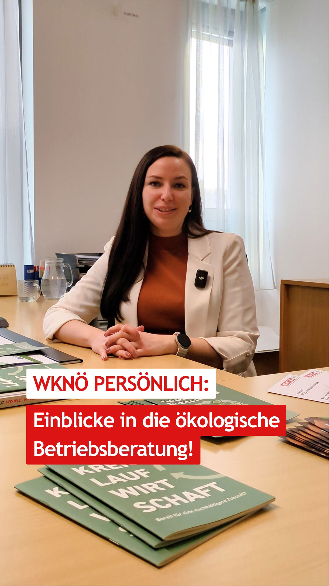 Eine Frau sitzt an einem Schreibtisch in einem B&uuml;ro. Vor ihr liegen Brosch&uuml;ren zum Thema &ouml;kologische Betriebsberatung. Auf dem Bild steht der Text &bdquo;WKN&Ouml; pers&ouml;nlich: Einblicke in die &ouml;kologische Betriebsberatung!&ldquo;.