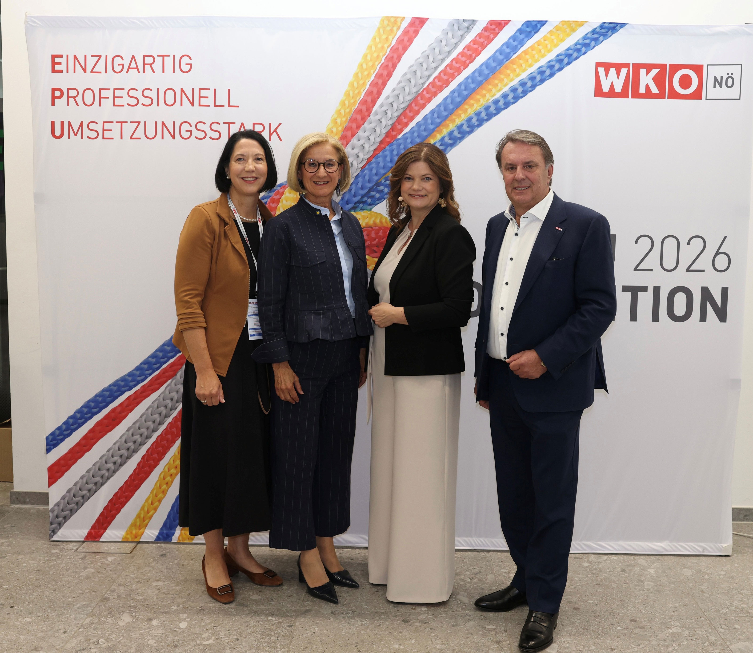 Vier Personen stehen vor einer WKO-N&Ouml; Fotowand mit buntem Seilmotiv und dem Slogan &bdquo;Einzigartig, professionell, umsetzungsstark&ldquo; im Rahmen der EPU Convention 2026.