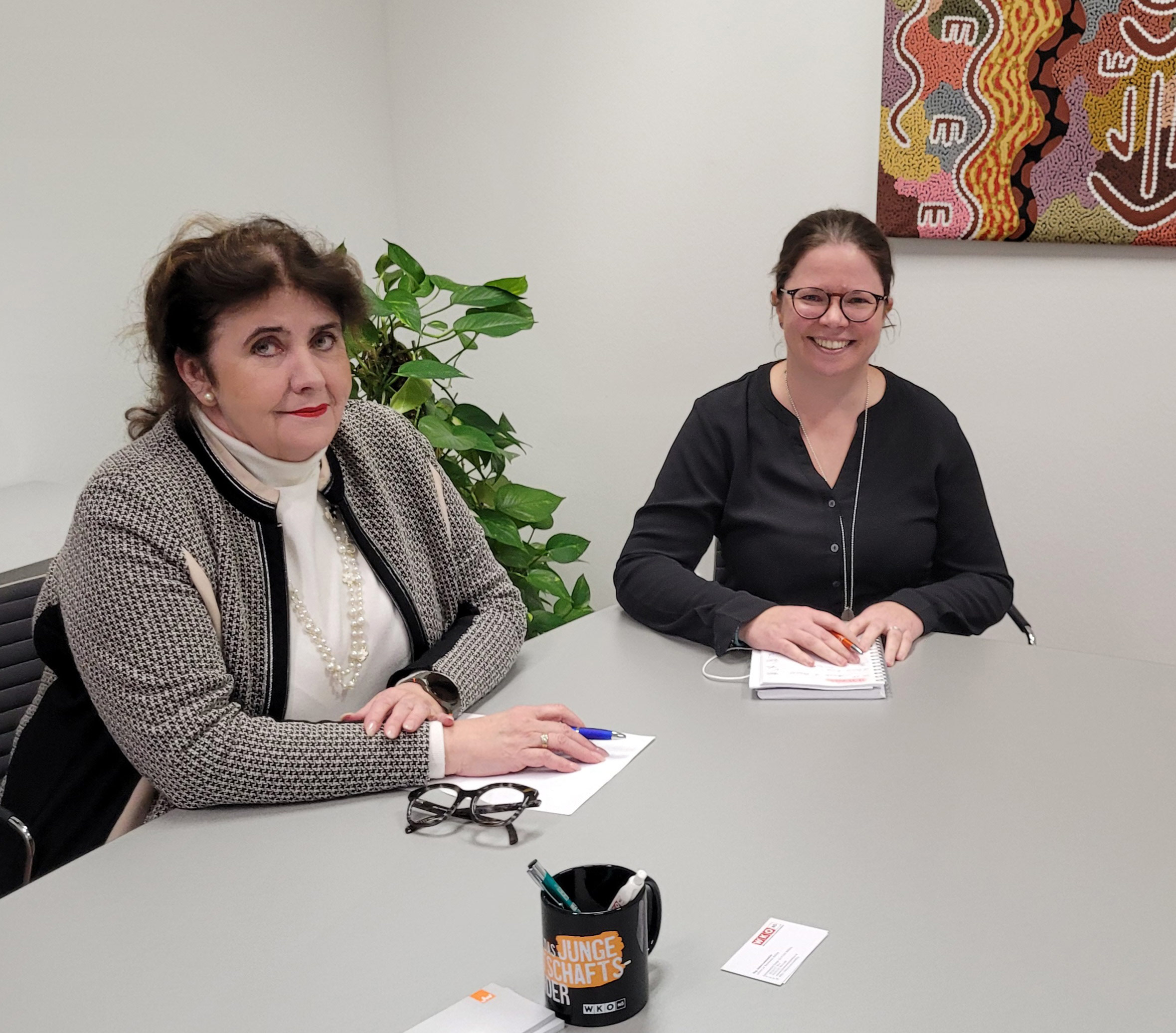 Zwei Personen sitzen am Tisch und unterhalten sich.