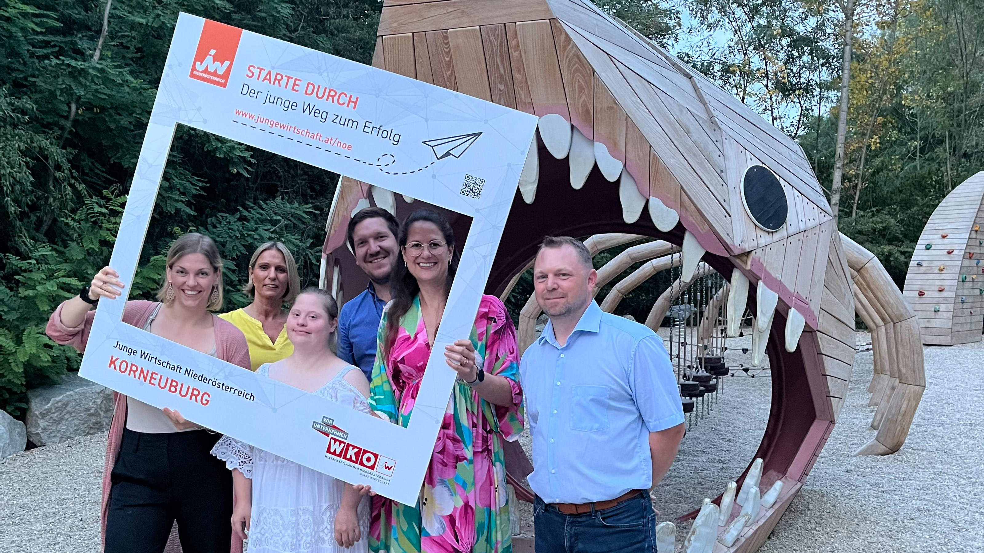 Gruppenbild mit JW-Bilderrahmen vor einem Holzfossilienskelett.