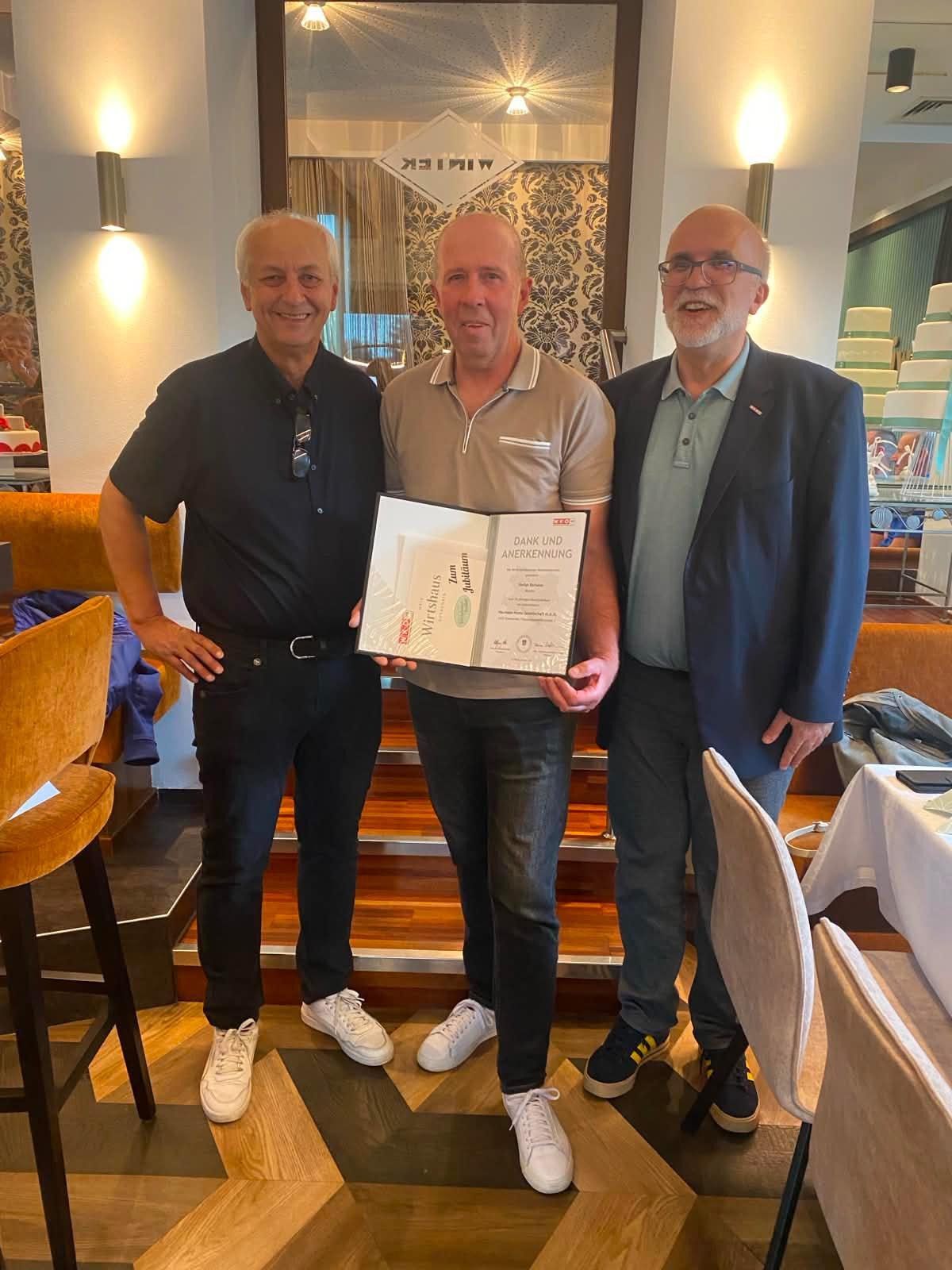 Baumeister Hermann Hums, Stefan Bartalos mit Urkunde, Bezirksstellenleiter Thomas Petzel 