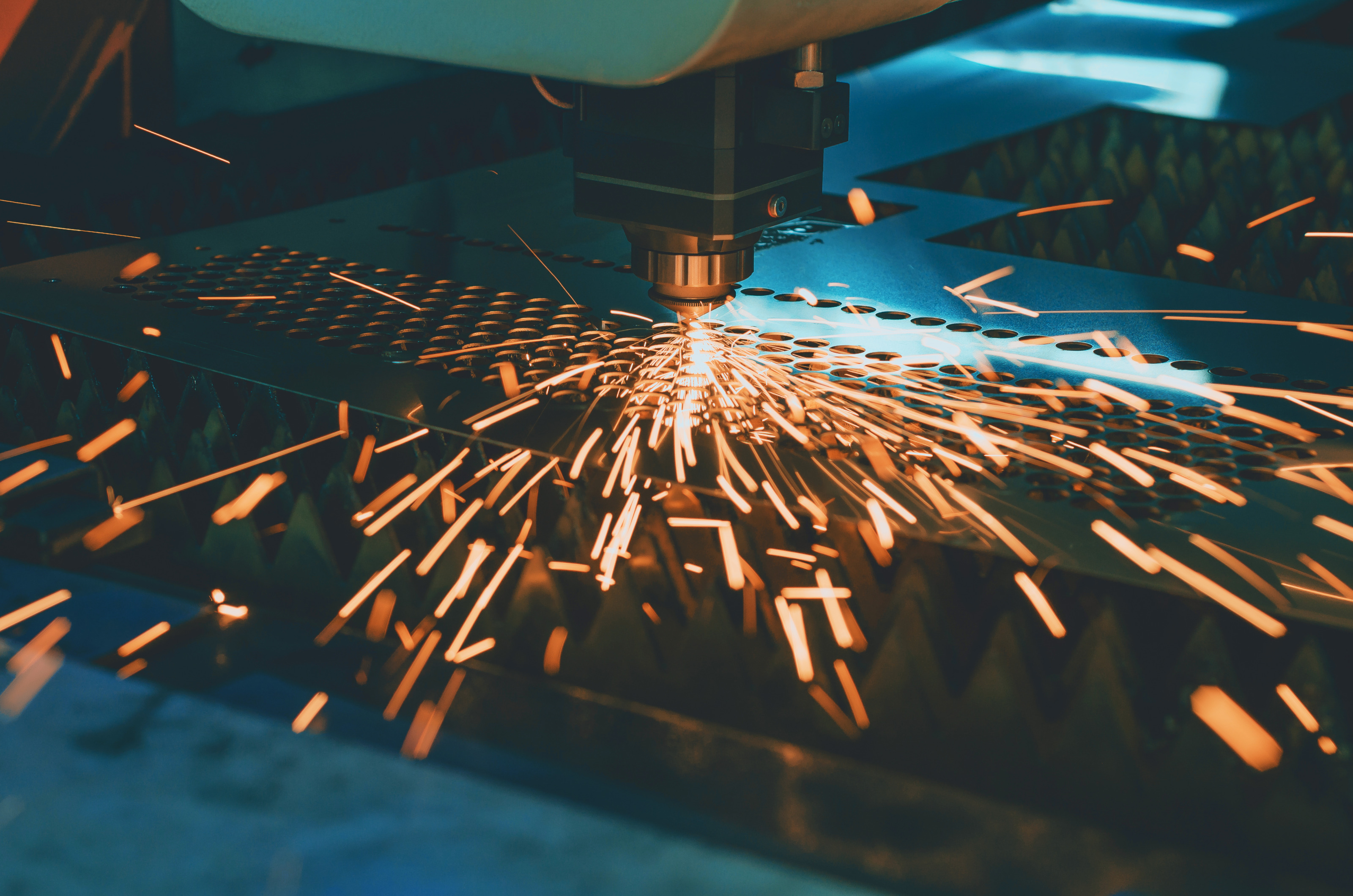 Nahaufnahme eines Lasers, der in eine d&uuml;nne Metallplatte L&ouml;cher lasert
