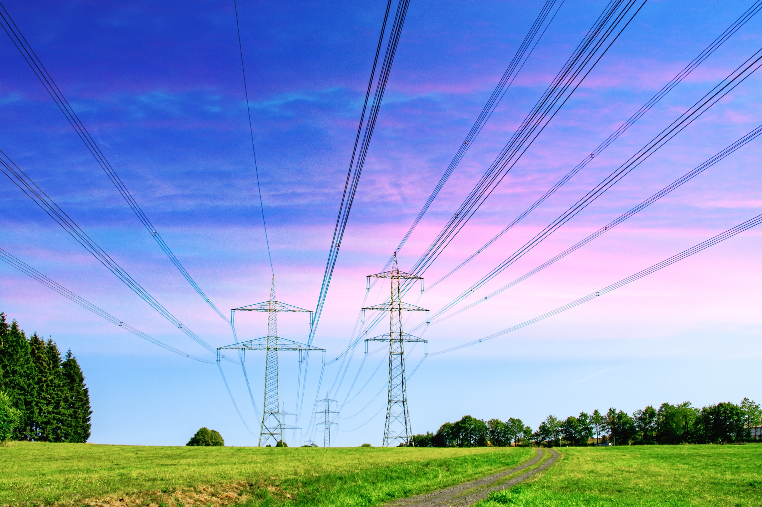 Stromtrasse in einer Landschaft von Wiesen und W&auml;ldern 