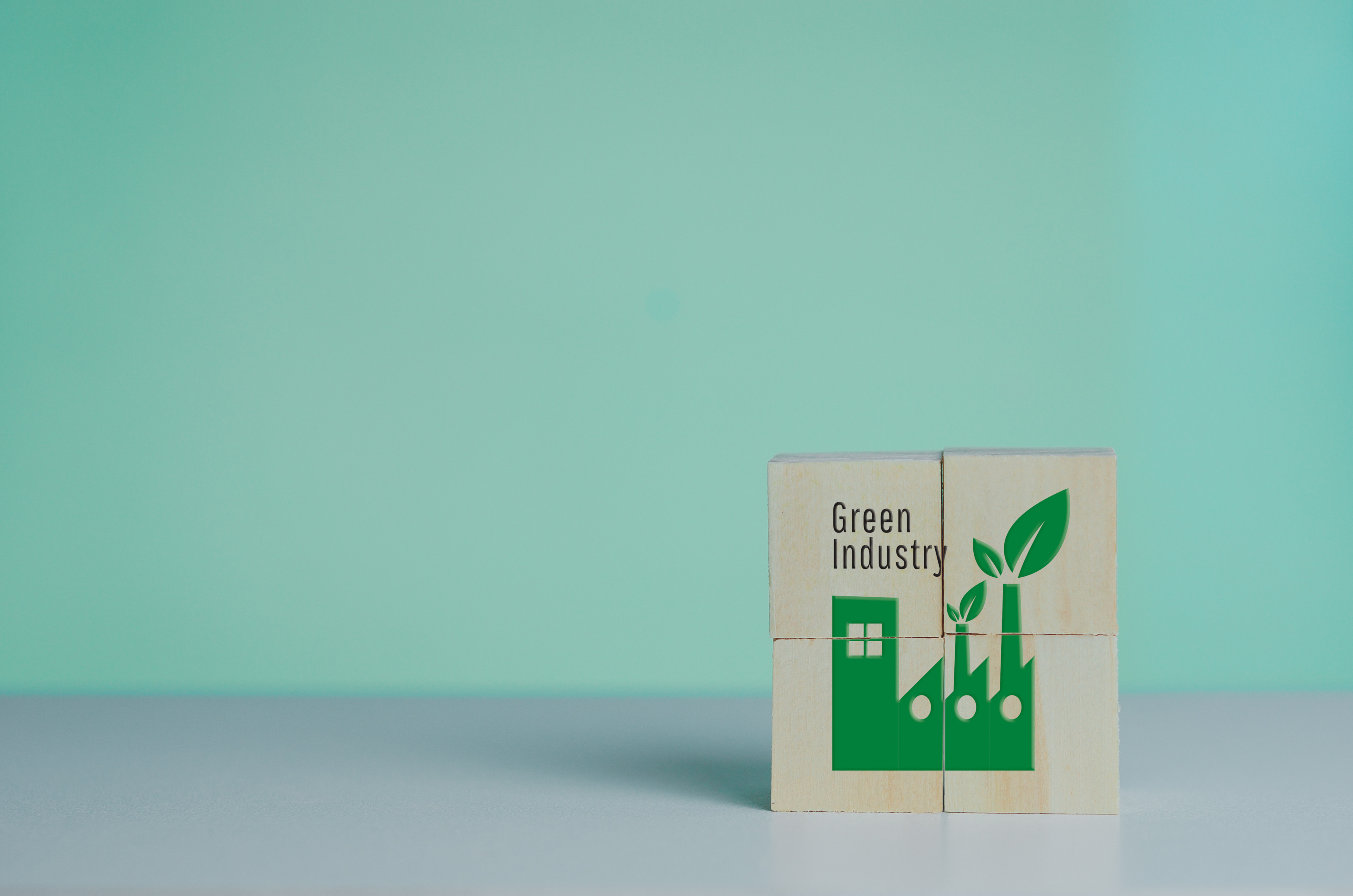 Auf Holzw&uuml;rfeln ist eine gr&uuml;ne Fabrik aufgezeichnet. Daneben steht Green Industry