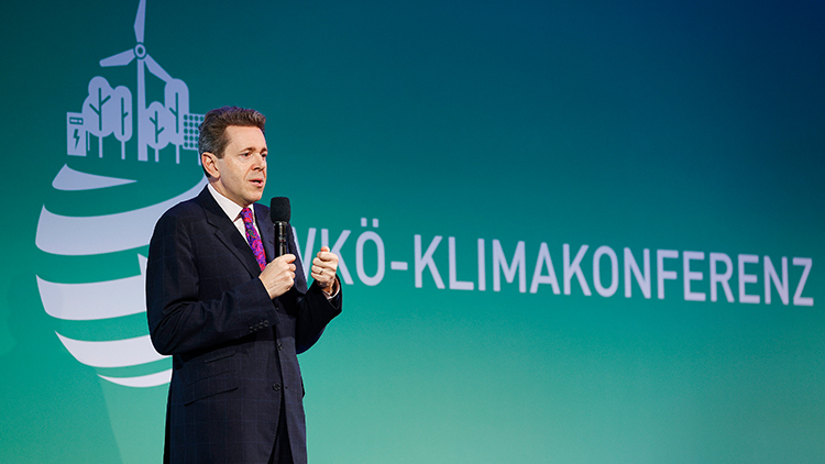 Mahrer auf B&uuml;hne in Mikrofon sprechend, im Hintergrund Schriftzug WK&Ouml;-Klimakonferenz