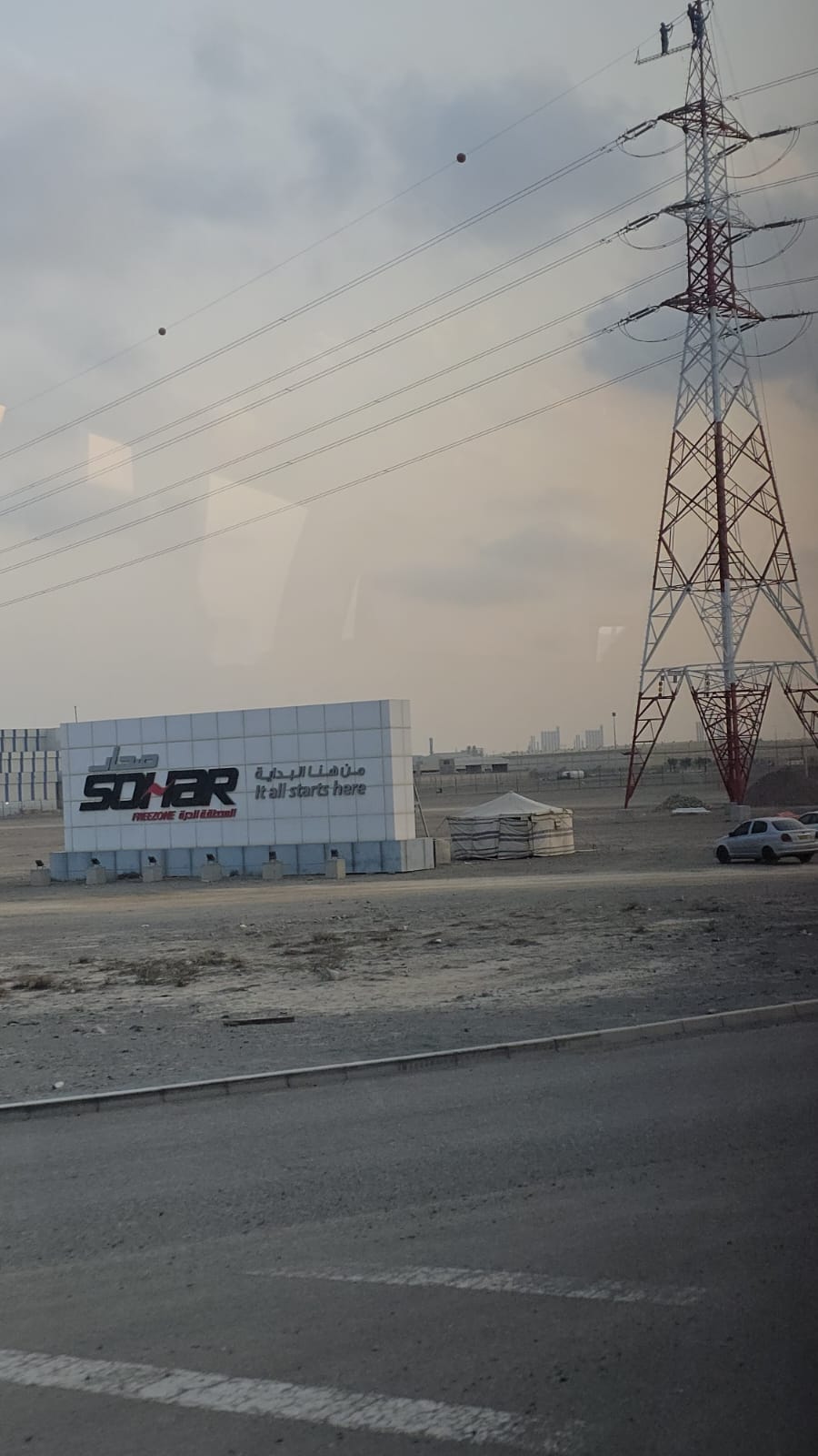 Neben einer Stra&szlig;e ist auf einem steinernen Feld ein gro&szlig;es Firmenschild, auf dem Sonar, es beginnt alles hier, steht