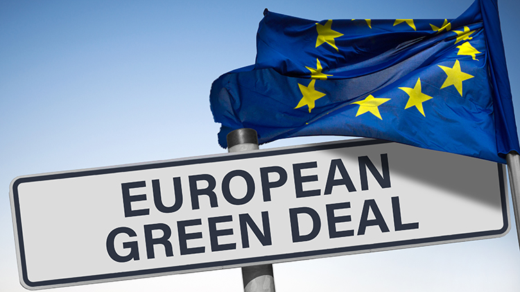 Schild mit Schriftzug European Green Deal, darüber im Wind wehende EU-Flagge