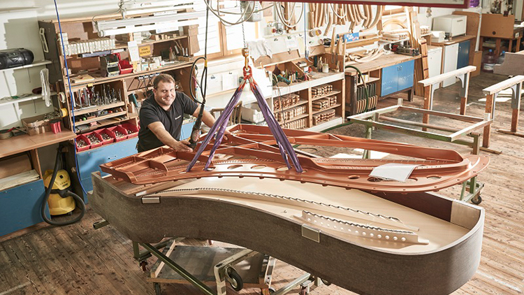 Person beim Bauen eine Klavierflügels in Werkstatt