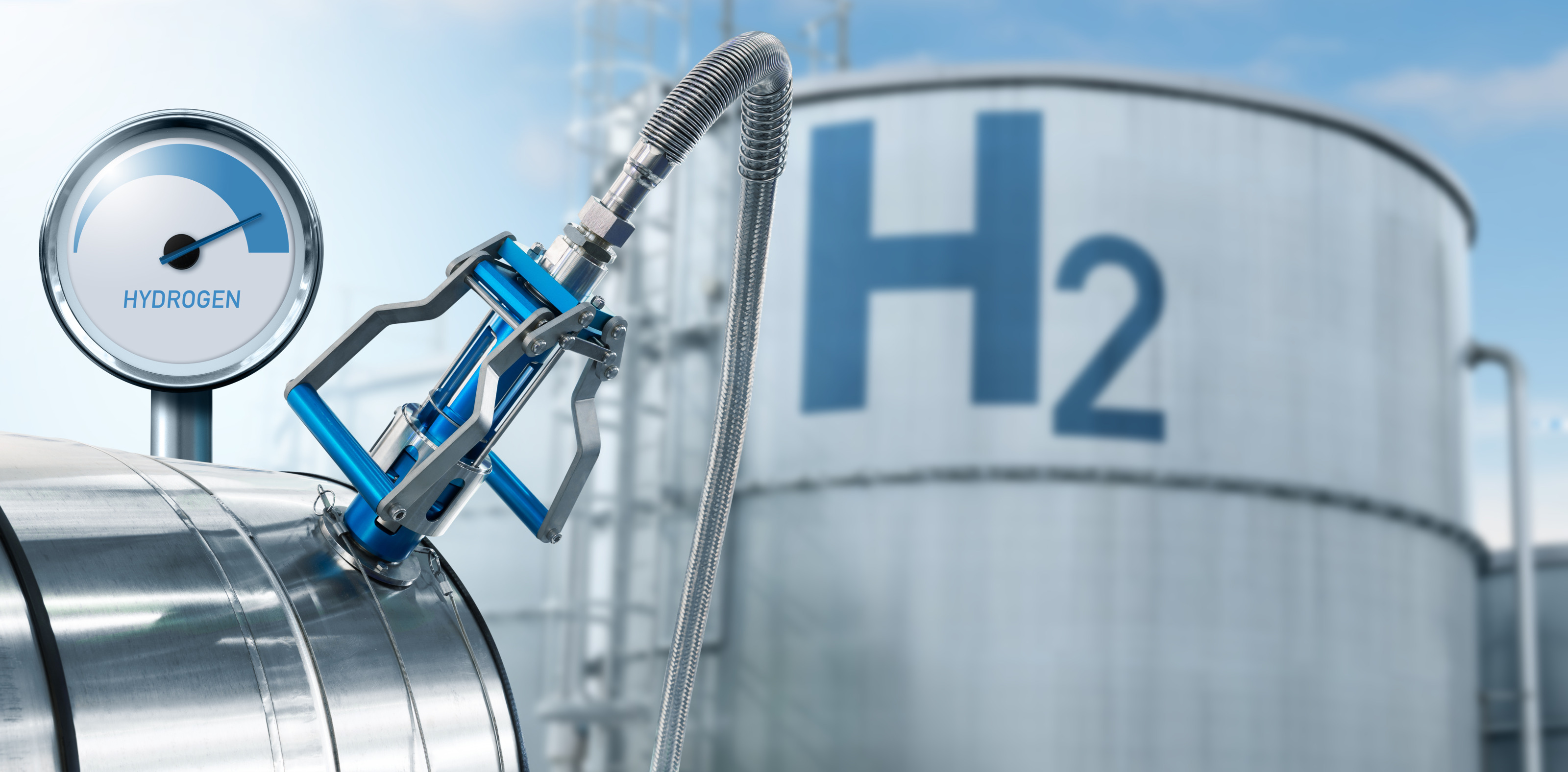 Fokus auf Zapfhahn einer Wasserstoffanlage mit Druckanzeige, im Hintergrund großer Container mit Beschriftung H2