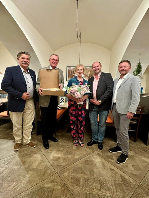Drei Personen, eine Person h&auml;lt einen Blumenstrau&szlig;.