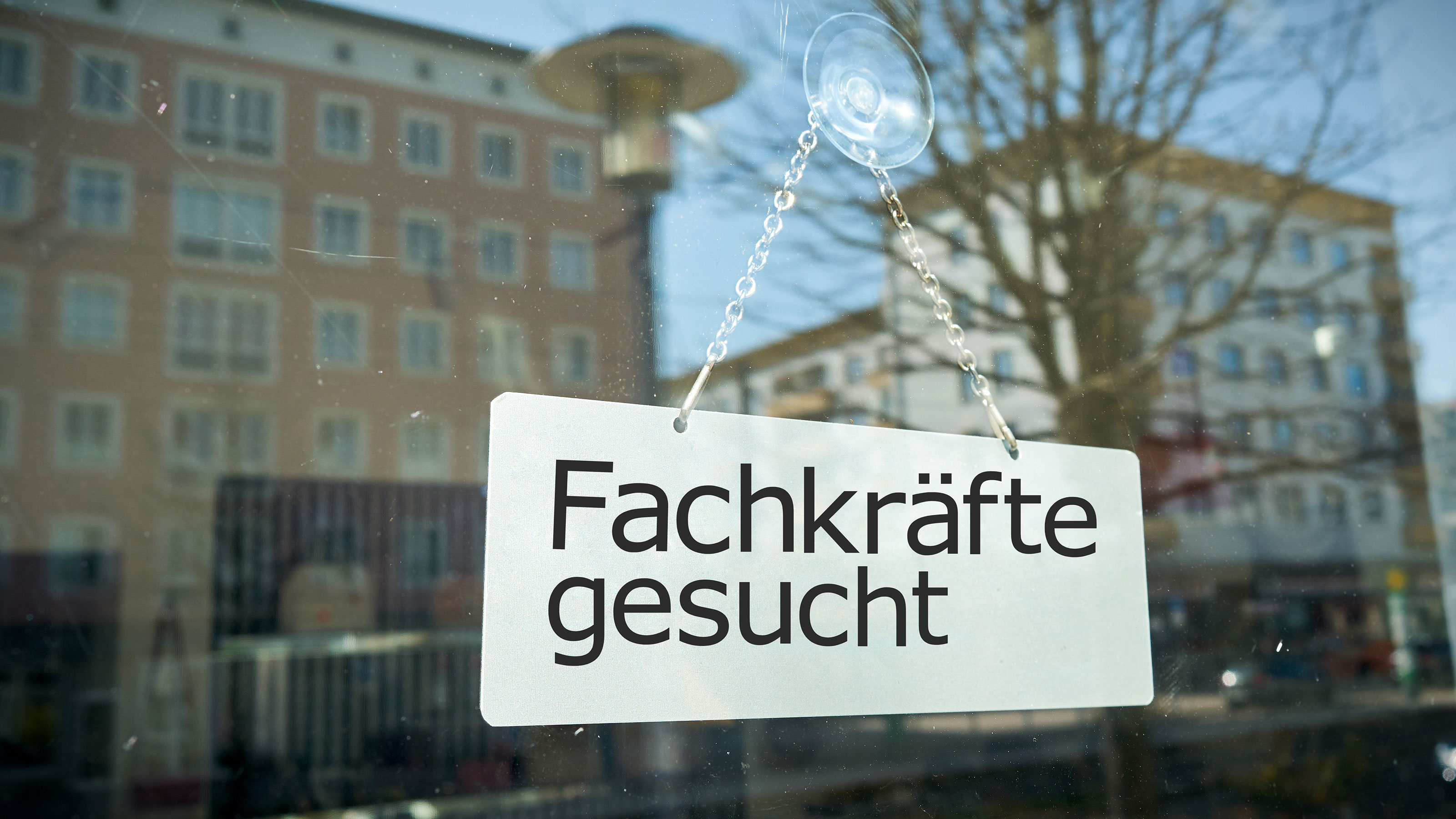 fachkräfte gesucht schild hängt auf fenster