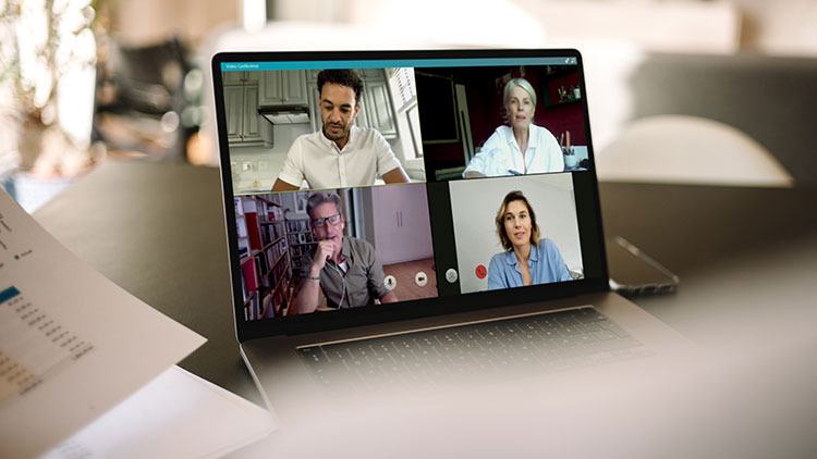 Laptopbildschirm mit vier Personen auf dem Monitor